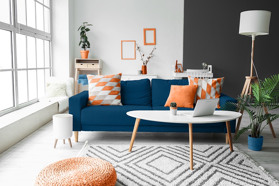 Blauwe woonkamer met oranje accessoires